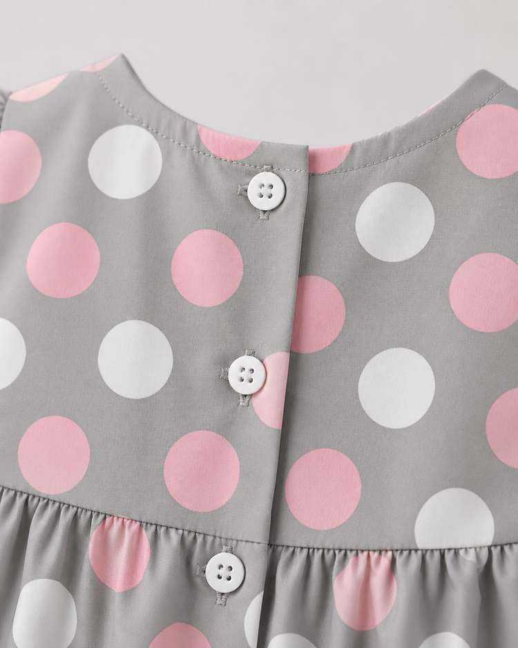 Baby wearing Anaario Blush Dot Tiered grey with pink and white polka dots tiered dress set, newborn to 24 months