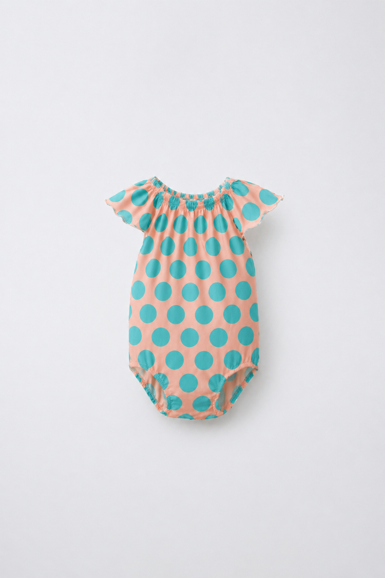 Baby wearing Anaario Peach Aqua Polka Dot Flutter romper, newborn to 24 months