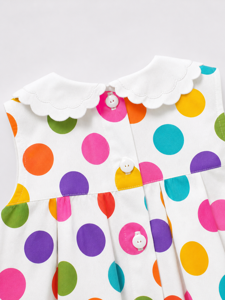 Baby wearing Anaario Rainbow Dot Pinafore white with multicolour polka dots dress, newborn to 24 months