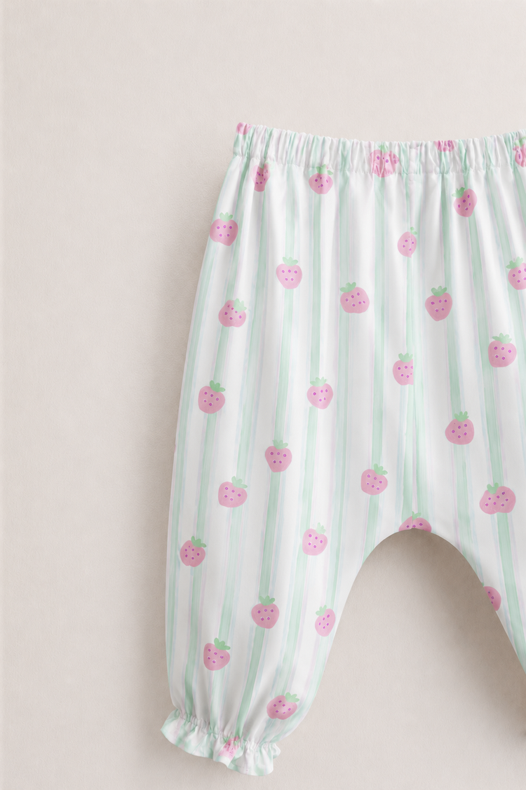 Baby wearing Anaario Strawberry Wrap white with pink strawberry prints and mint stripes co-ord set, newborn to 24 months