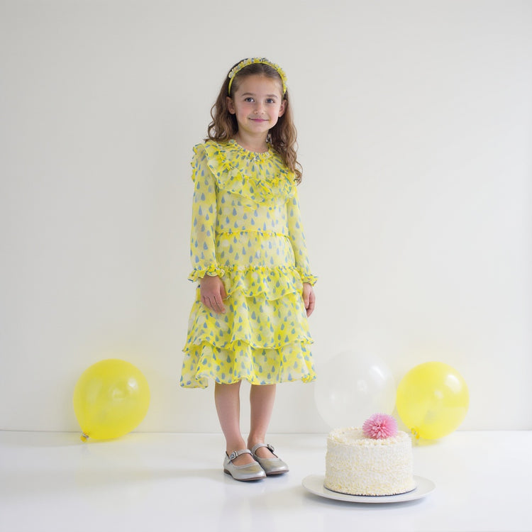Girl wearing Anaario Lemon-Drop Raindress, yellow organza dress with blue raindrop print