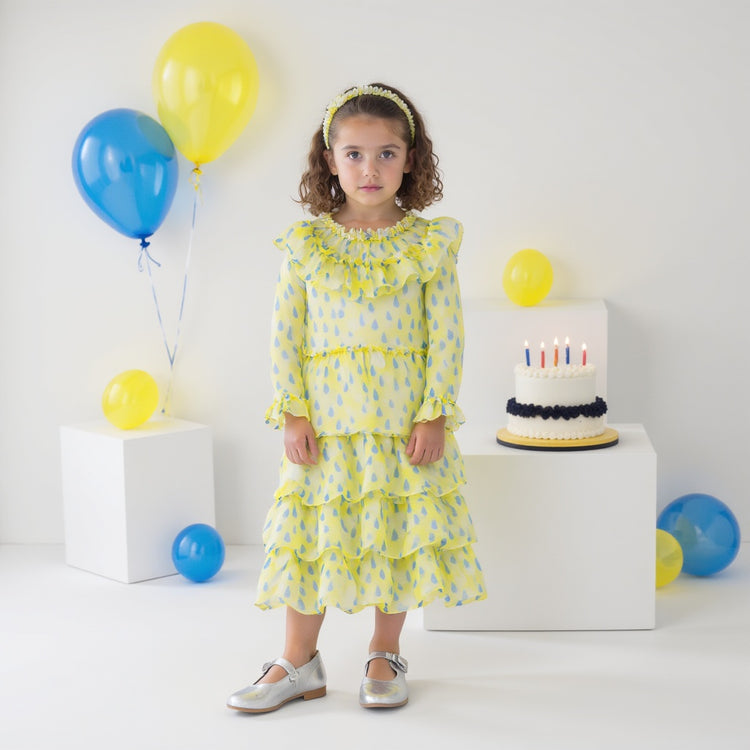 Girl wearing Anaario Lemon-Drop Raindress, yellow organza dress with blue raindrop print