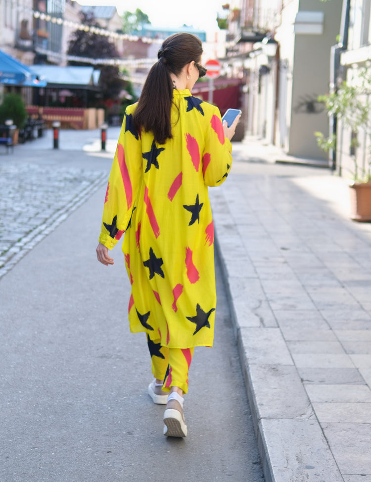 Person wearing Anaario Casablanca Co-ord Set, yellow duster with black star and coral brushstroke print over matching pants