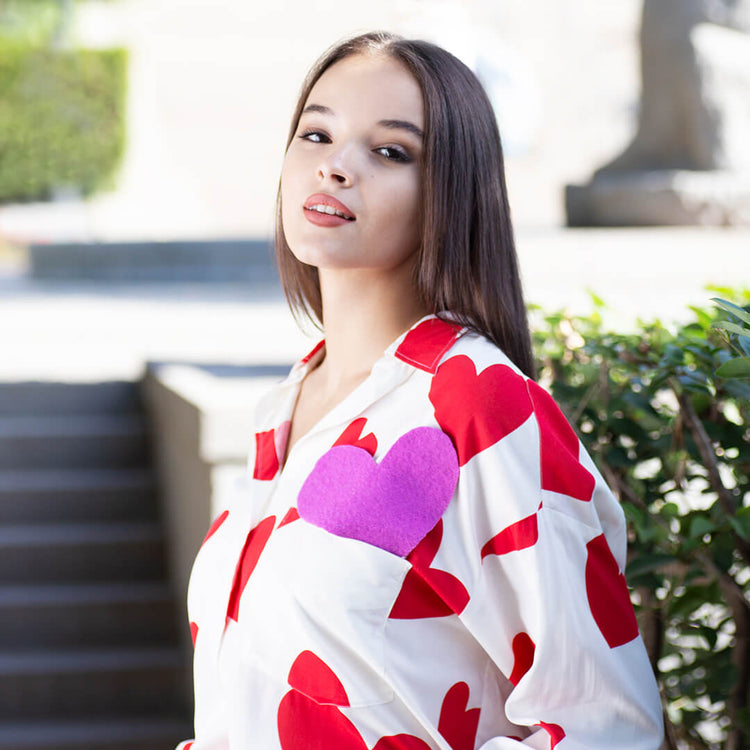 Woman wearing Anaario Love Island Shirt, white oversized shirt with red heart print