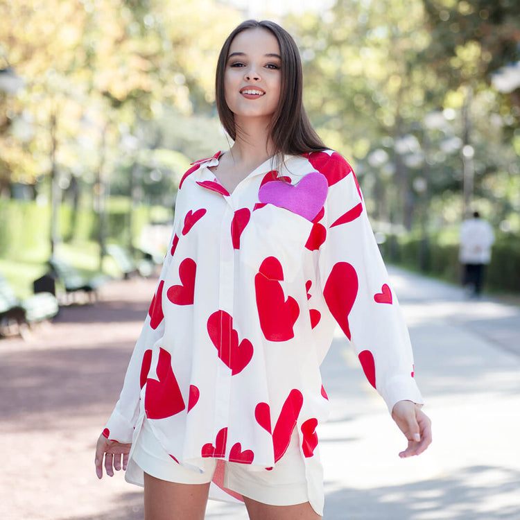 Woman wearing Anaario Love Island Shirt, white oversized shirt with red heart print