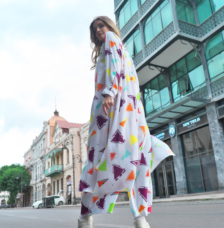 Person wearing Anaario Wild Wanderer Co-ord Set, white maxi duster with multicolor triangle print over matching pants
