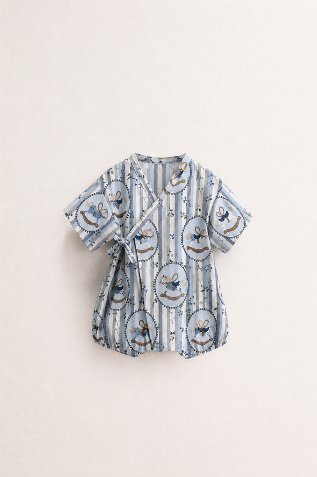 Baby wearing Anaario Blue Rocking Horse Wrap romper, premium organic cotton