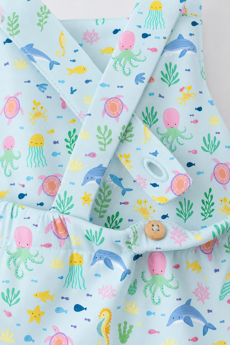 Baby wearing Anaario Sea Friends Pinafore light blue with ocean animals and sea-life prints romper, newborn to 24 months