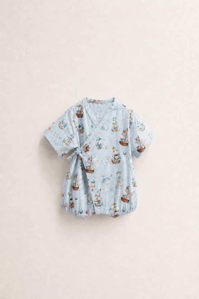 Baby wearing Anaario Ocean Sailor Wrap sky blue with boats whales penguins ocean prints romper, newborn to 24 months