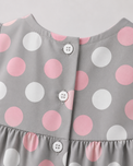 Baby wearing Anaario Blush Dot Tiered grey with pink and white polka dots tiered dress set, newborn to 24 months
