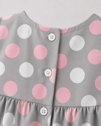 Baby wearing Anaario Blush Dot Tiered grey with pink and white polka dots tiered dress set, newborn to 24 months