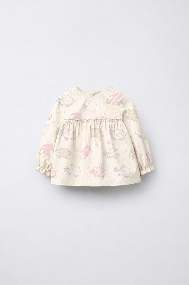 Baby wearing Anaario Cream Sheep Peplum cream with pastel sheep prints co-ord set, newborn to 24 months