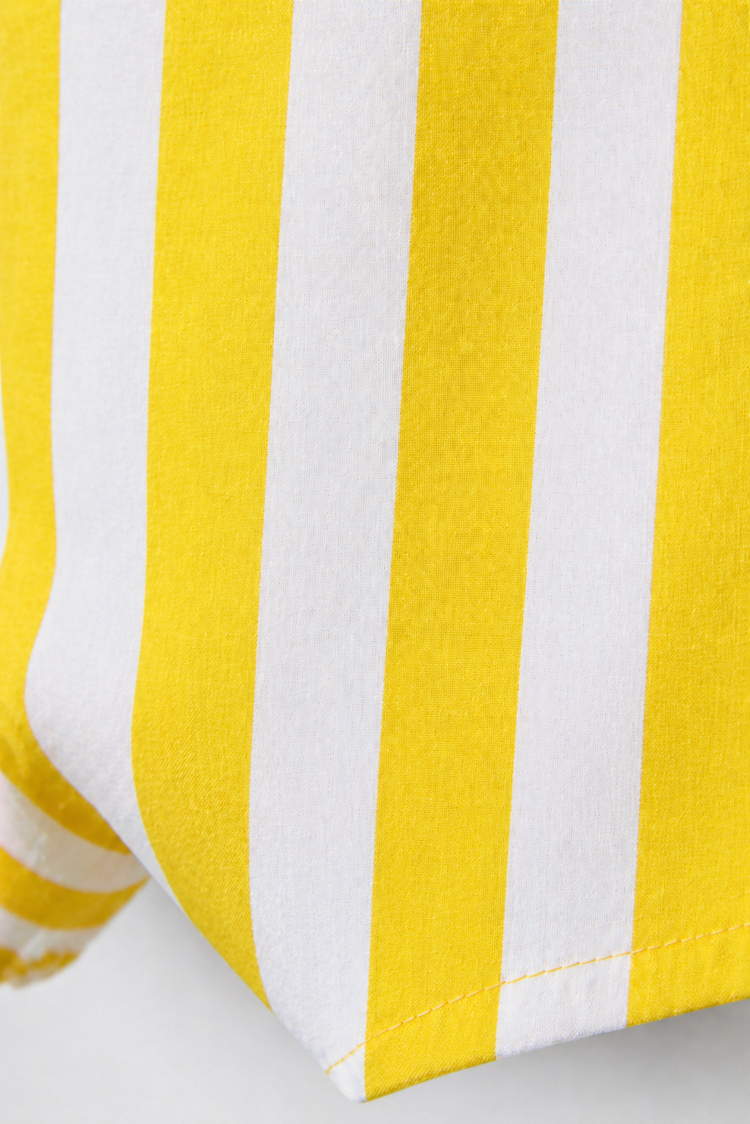 Baby wearing Anaario Yellow Stripe romper, yellow and white striped dungaree-style romper, newborn to 24 months