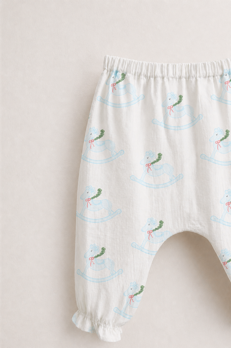 Baby wearing Anaario Rocking Horse Wrap ivory with soft blue rocking horse prints co-ord set, newborn to 24 months