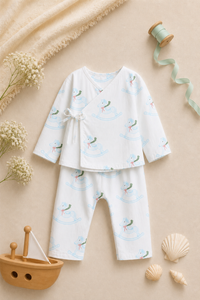 Baby wearing Anaario Rocking Horse Wrap ivory with soft blue rocking horse prints co-ord set, newborn to 24 months