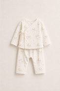 Baby wearing Anaario Dreamy Sheep Wrap ivory with clouds moons rainbows sheep prints co-ord set, newborn to 24 months