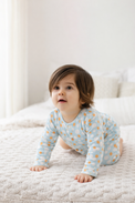 Baby wearing Anaario Ivory and Tangerine Poppy Raindrops organic mulmul cotton Sakura set, newborn to 24 months