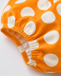 Baby wearing Anaario Orange Polka Bow orange with white polka dots dress set, newborn to 24 months