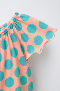 Baby wearing Anaario Peach Aqua Polka Dot Flutter romper, newborn to 24 months