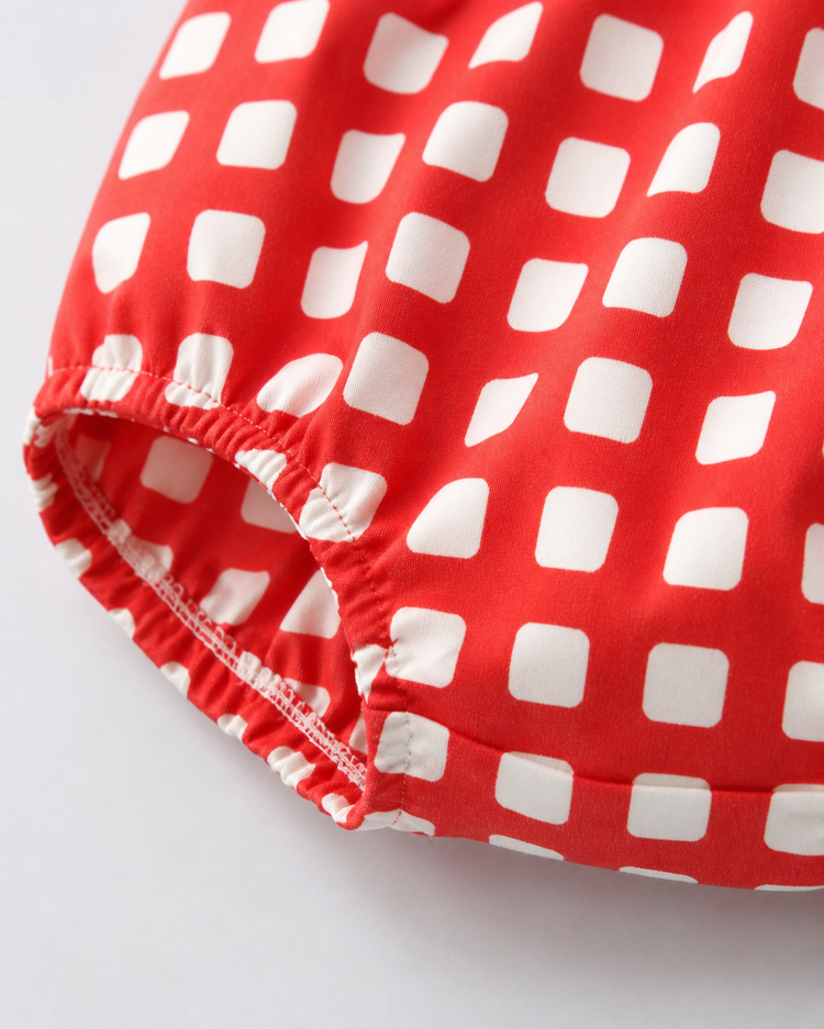 Baby wearing Anaario Cherry Check Bubble red and white gingham puff sleeve romper, newborn to 24 months
