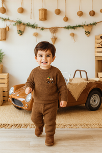 Baby boy wearing brown fleece set with car patch