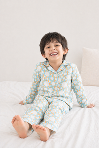 Boy wearing Anaario Ivory and Tangerine Poppy Raindrops Night Suit
