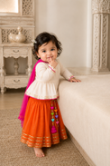 Ivory peplum kurta with orange flared skirt and hot pink dupatta with heart tassels for baby girl