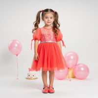 Girl wearing Anaario Coral Blossom Princess Dress, coral puff-sleeve tulle dress with beaded bodice