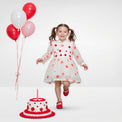 Girl wearing Anaario Polka-Dot Pixie Dress, white organza dress with red polka dot print