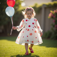 Girl wearing Anaario Polka-Dot Pixie Dress, white organza dress with red polka dot print