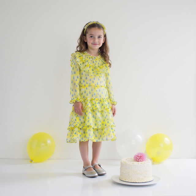 Girl wearing Anaario Lemon-Drop Raindress, yellow organza dress with blue raindrop print