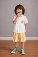 Boy wearing Anaario Sunwave Pocket Shirt Set, white pocket shirt with matching yellow wavy-striped shorts