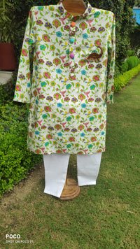 Boy wearing Anaario Garden Kurta Set, white kurta with multicolor floral garden print and dinosaur toy-pocket applique