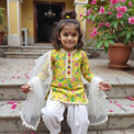 Girl wearing Anaario Lime-Poppy Patiala Set, lime yellow floral print kurta with white patiala pants and cream dupatta