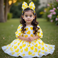 Girl wearing Anaario yellow organza party dress with hearts motif