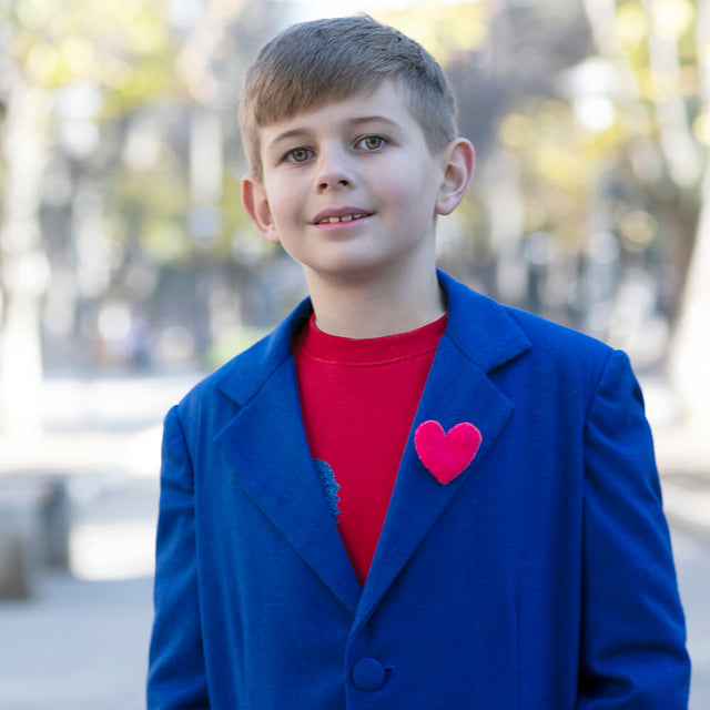 Boy wearing Anaario Arctic Coat, royal blue longline coat with red felt heart pin