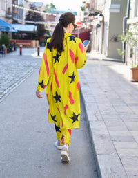Person wearing Anaario Casablanca Co-ord Set, yellow duster with black star and coral brushstroke print over matching pants