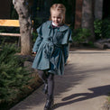 Girl wearing Anaario Diana Capelet Coat, teal wool-look coat with cape collar and tie waist