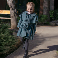 Girl wearing Anaario Diana Capelet Coat, teal wool-look coat with cape collar and tie waist
