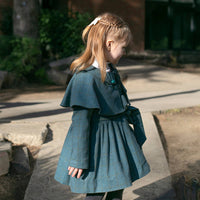 Girl wearing Anaario Diana Capelet Coat, teal wool-look coat with cape collar and tie waist