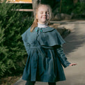 Girl wearing Anaario Diana Capelet Coat, teal wool-look coat with cape collar and tie waist