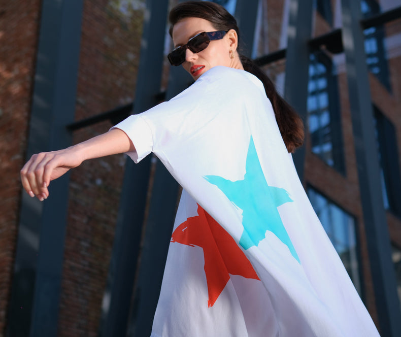 Woman wearing Anaario K Pop Krush Shirt Dress, white oversized shirt dress with teal and orange star graphic