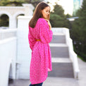 Woman wearing Anaario La Belle Tunic, pink floral print tunic with yellow flower patch and belted waist