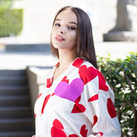 Woman wearing Anaario Love Island Shirt, white oversized shirt with red heart print