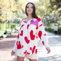 Woman wearing Anaario Love Island Shirt, white oversized shirt with red heart print
