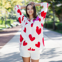 Woman wearing Anaario Love Island Shirt, white oversized shirt with red heart print