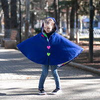 Girl wearing Anaario Mulan Cape Coat, royal blue hooded cape coat with heart button closures