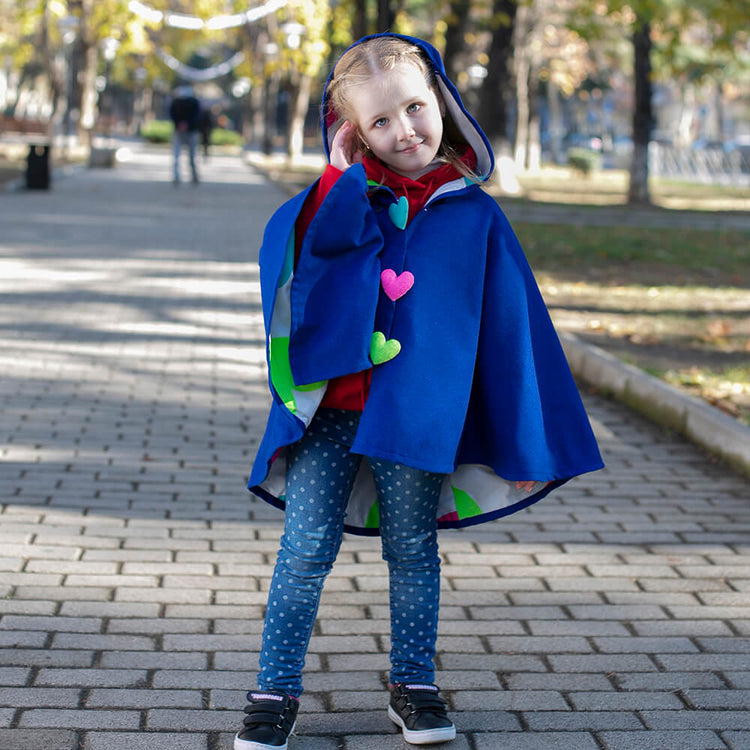Girl wearing Anaario Mulan Cape Coat, royal blue hooded cape coat with heart button closures
