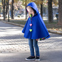 Girl wearing Anaario Mulan Cape Coat, royal blue hooded cape coat with heart button closures