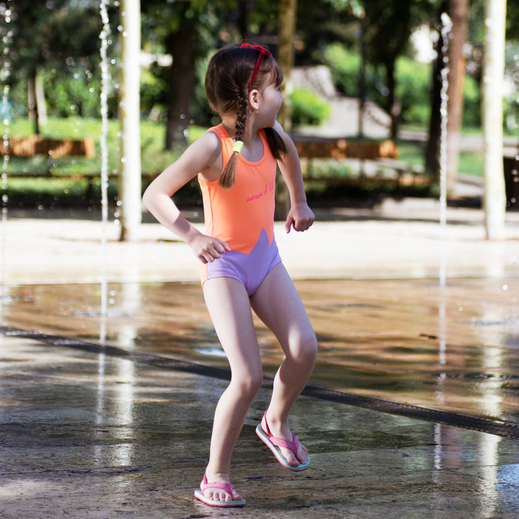 Girl wearing Anaario Orange Purple Star One Piece swimsuit, orange and lilac colorblock one-piece swimsuit with star-point seam design